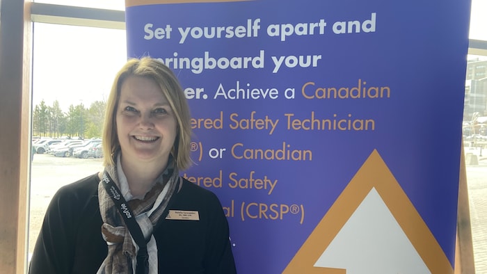 Natalie Carscadden  devant une pancarte. 