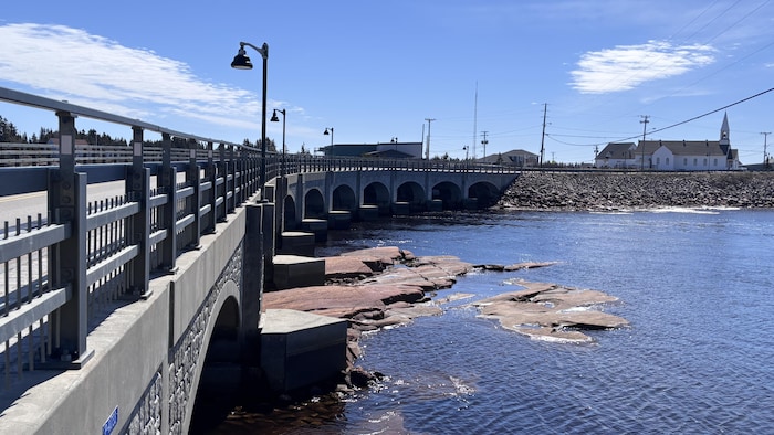 Un pont enjambe la rivière Natashquan et mène jusqu'à l'église.