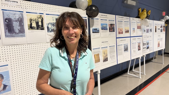 Nathalie Cloutier pose devant les panneaux explicatifs de l'histoire de Sheldrake.