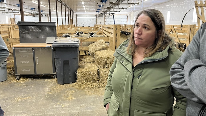Nathalie Lemieux discute avec des producteurs agricoles dans une étable.