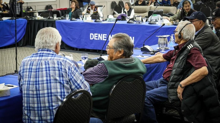 Des personnes assises autour d'une longue table.