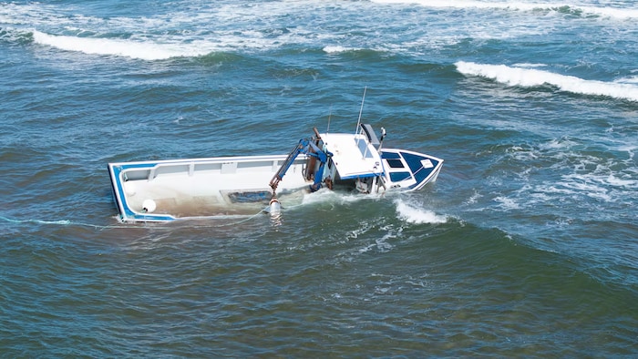Un petit bateau de pêche à demi rempli d'eau.