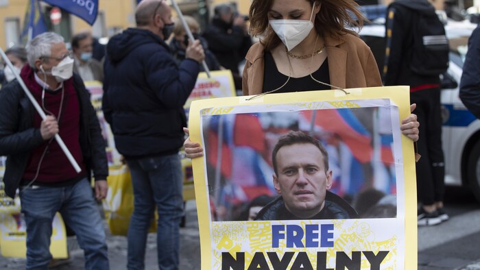 Une manifestante tient une photo du chef de l'opposition russe incarcéré Alexeï Navalny lors d'une manifestation. 