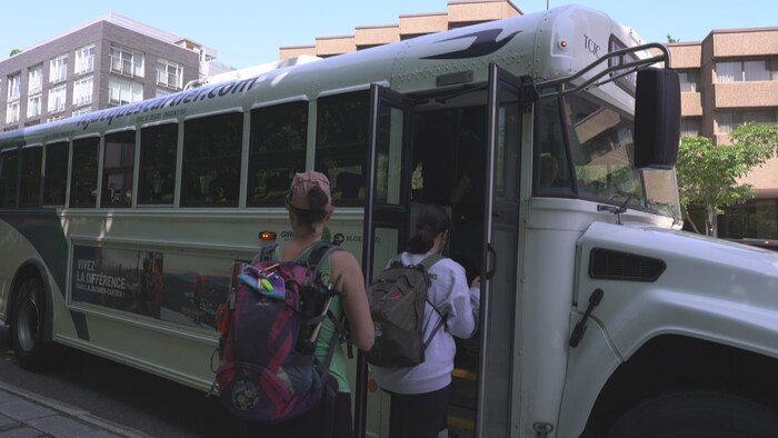 Des passagers montent à bord d'un autobus.