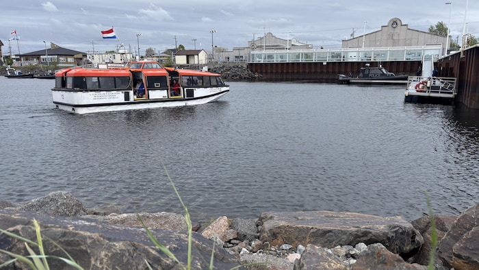 Les croisiéristes du Volendam sont transportés à bord de petits bateaux jusqu'au quai de la marina de Sept-Îles.
