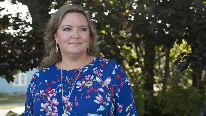 La docteure Robyn MacQuarrie pose devant des arbres.