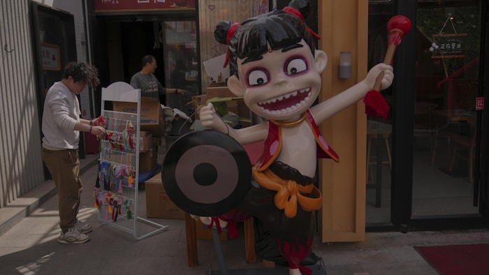 Elle est à l'entrée d'une boutique.