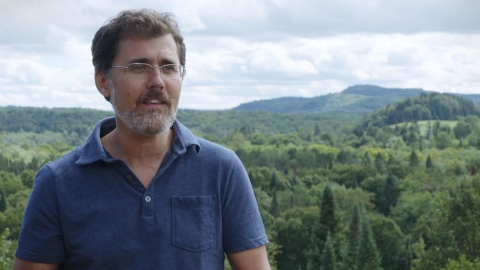 Pierre-Olivier Pineau, expert en politiques énergétiques et professeur à HEC Montréal, devant un paysage de montagne et forêt.