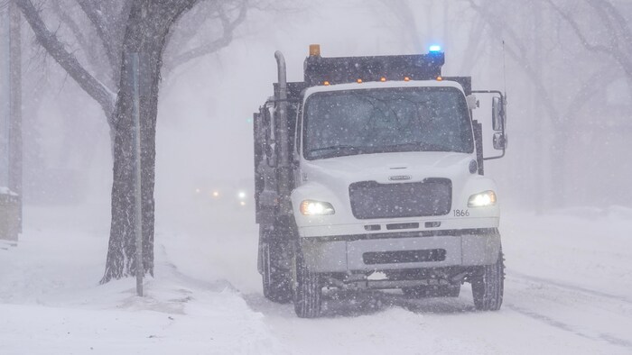 Un camion roule dans une rue de Saskatoon, en Saskatchewan, durant une tempête de neige, le 26 février 2024.