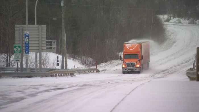 Camion sur route enneigée.