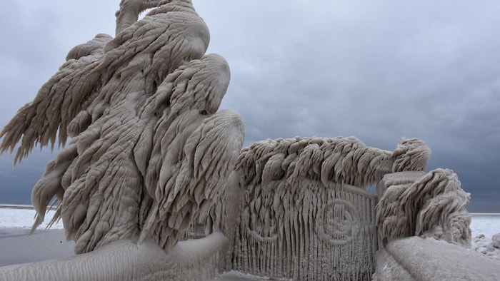 Une sculpture étrange enrobée de neige au bord du lac.