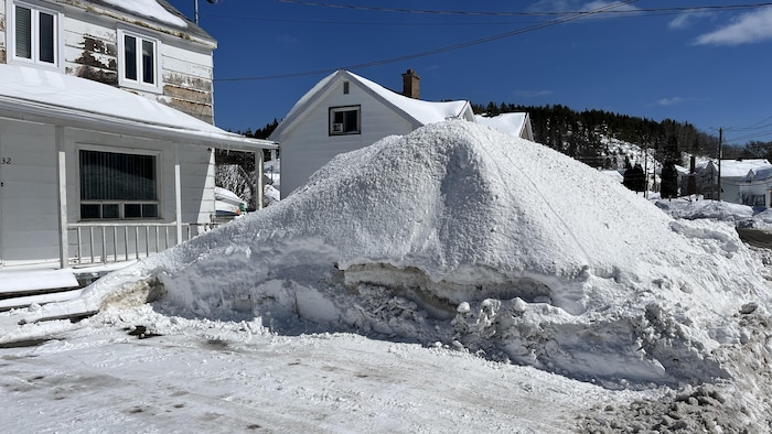 Un tas de neige devant une maison.