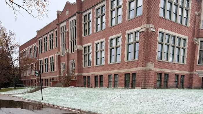 L'extérieur d'un bâtiment avec un peu de neige au sol.