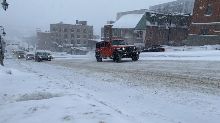 Une voiture sur la route, dans la neige.