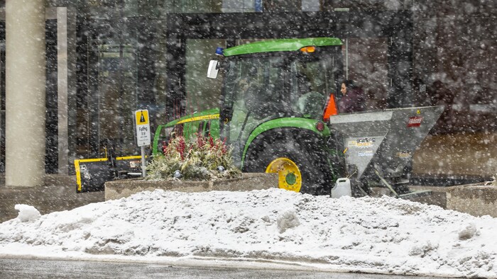 Des employés à Toronto jettent du sel sur les bancs de neige pour