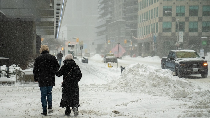 Des gens marchent dans la neige au centre-ville de Toronto.