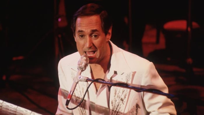 Neil Sedaka chante et joue du piano.