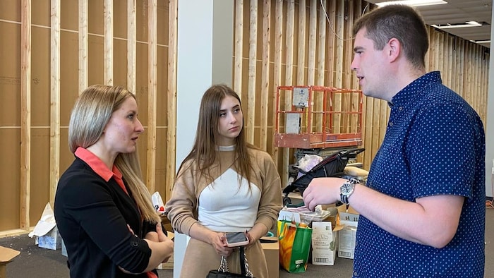 Voloshanavskiy and Havina meet with Callum Morrison, an Altona resident who is helping resettle newcomer families. They are in the donation depot, where people have been dropping off furniture and household goods to fill homes for the refugees.