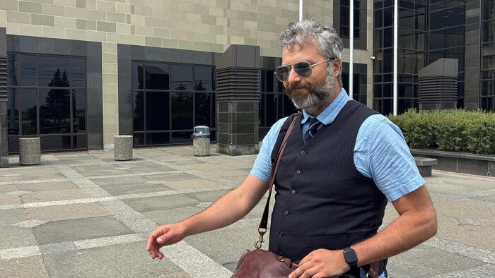 Une personne barbue sort du palais de justice de Moncton. 