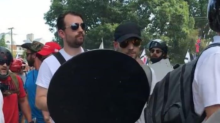 Un homme porte un bouclier dans une manifestation.
