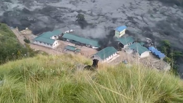 Cette image extraite d'une vidéo de l'AFPTV tournée le 11 octobre 2026 montre les eaux de crue détruisant des bâtiments le long de la rivière Budhi Gandaki.