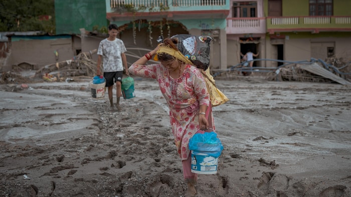 Une femme marche dans la boue.
