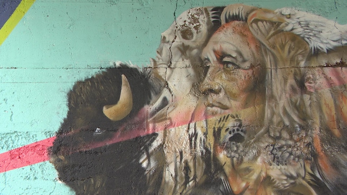 Murale coloré représentant un bison aîné superposé à un jeune bison