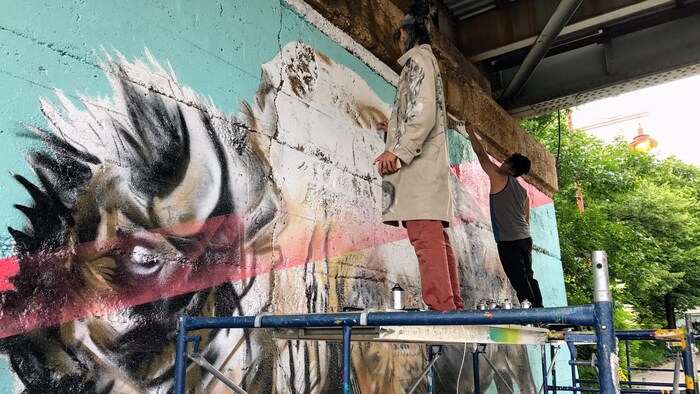 Les artistes Nereo II et John Padua en pleine création de l'oeuvre inaugurée le 1er juillet à La Fourche à Winnipeg.