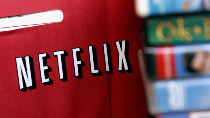 Une enveloppe Netflix derrière des boîtiers de DVD.