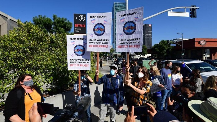 Des personnes tiennent des pancartes.