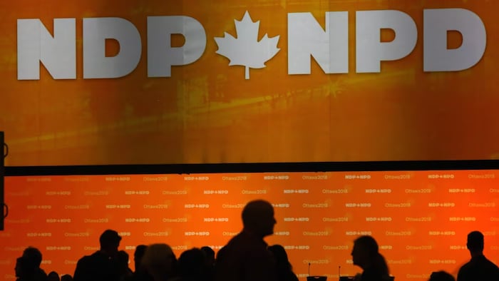 Le logo du NPD et des gens marchent devant. 
