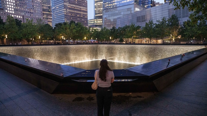 Une personne contemple le bassin réfléchissant sud avant la cérémonie commémorative annuelle du 11 septembre au Mémorial et musée national du 11 septembre, le 11 septembre 2025 à New York. 