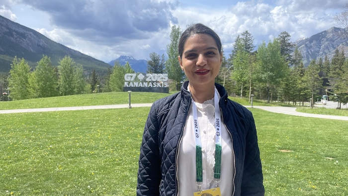 Une femme sourit devant les Rocheuses albertaines.