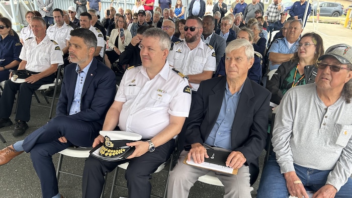 Une petite foule sous une grande tente.