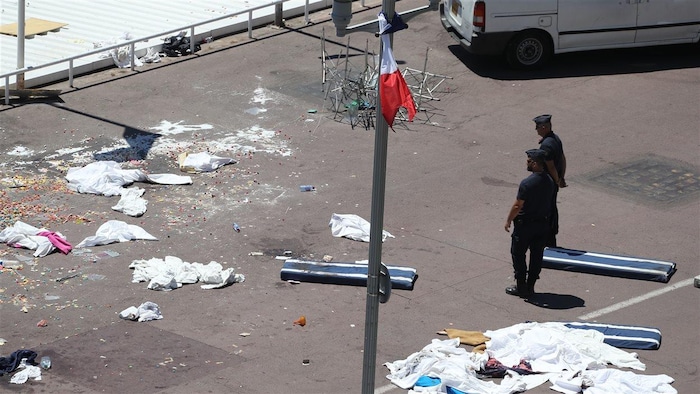 Des policiers sur la promenade des Anglais scrutent la scène de l'attentat.