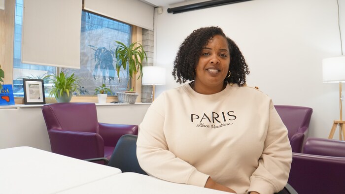 Elle pose pour une photo dans un bureau.