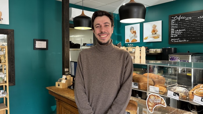 Nicolas Dot sourit devant des étagères du boulangerie.