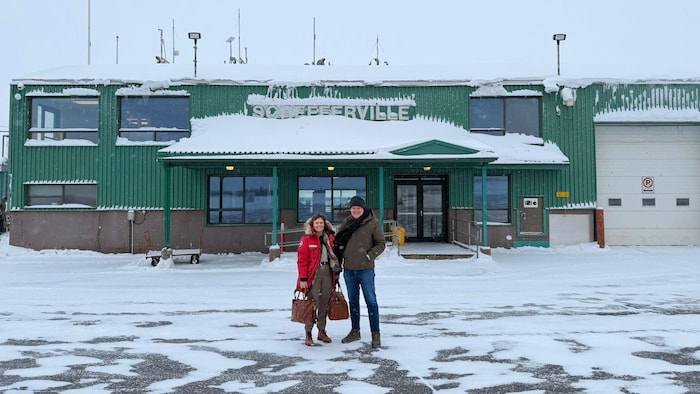 Un homme et une femme côte à côte devant l'aéroport de Schefferville, sur la Côte-Nord.