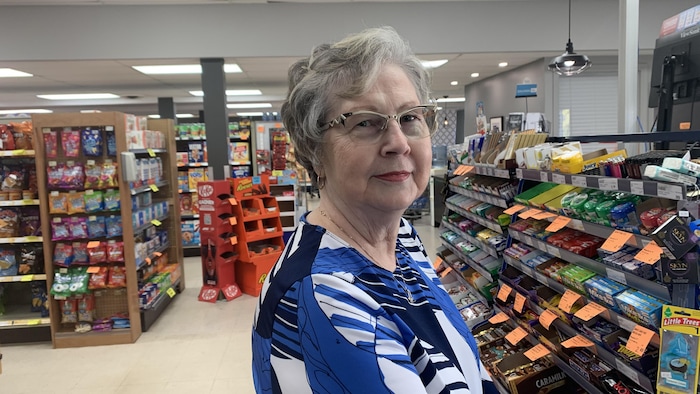 Une femme debout dans une épicerie.