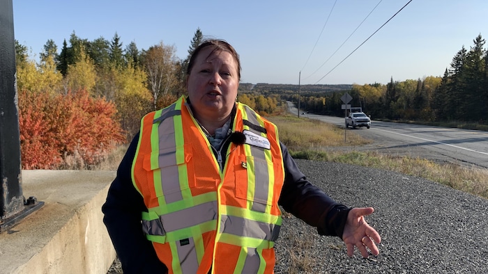 La porte-parole du MTQ en Abitibi-Témiscamingue, Nicole Gaulin debout sur le bord d'une route.