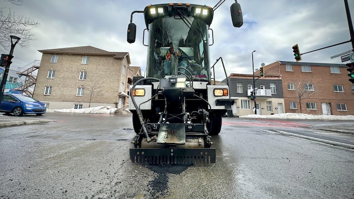 Un tracteur répare un nid-de-poule.
