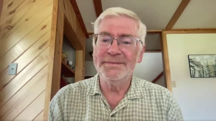 Homme avec lunette en réunion sur google meet.