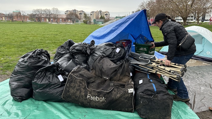 Niki Ottosen à côté d'une tente et de sacs poubelles. 
