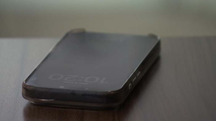 Un cellulaire posé sur une table.
