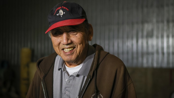 Un homme qui porte une casquette sourit.