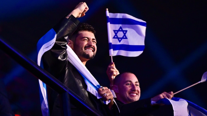 Noam Bettan entouré de drapeaux israéliens.