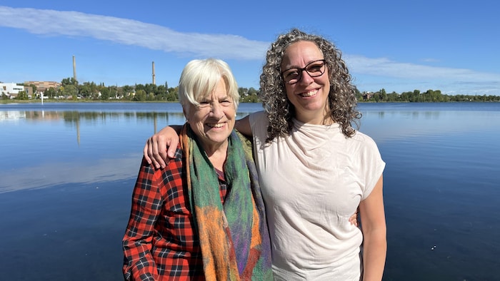 Betsy Damon et Geneviève Aubry posent au bord du lac Osisko, souriantes.