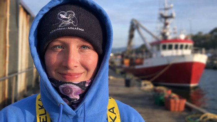 Noémie Bouma sourit devant un bateau.