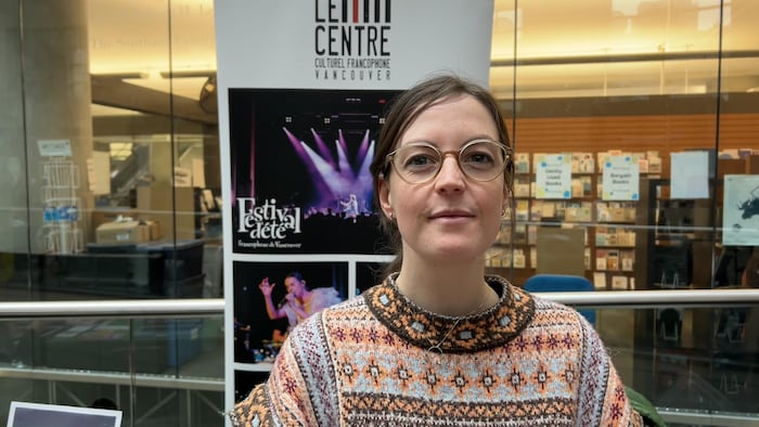 Noémie Delaire devant une banderole du Centre culturel francophone de Vancouver.