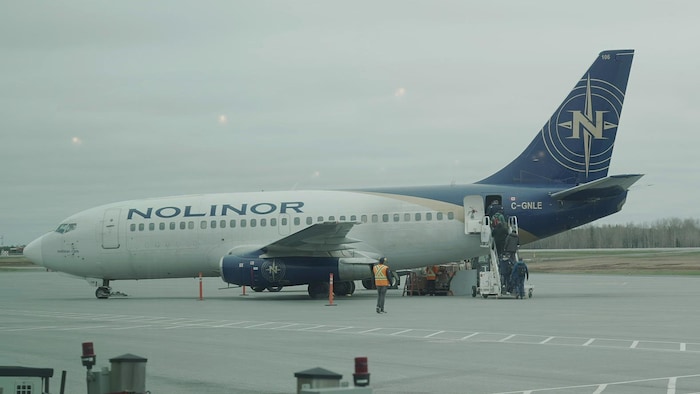 Des passagers embarquent dans un avion de Nolinor sur une piste de l'aéroport de Val-d'Or.